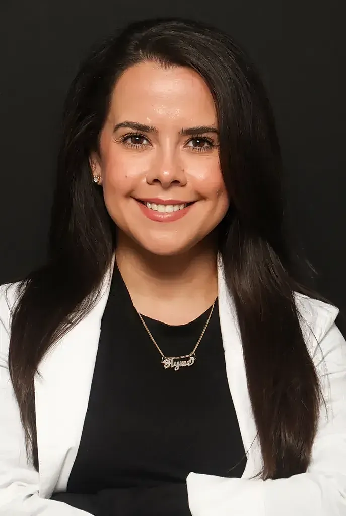 Smiling woman in professional attire against black background