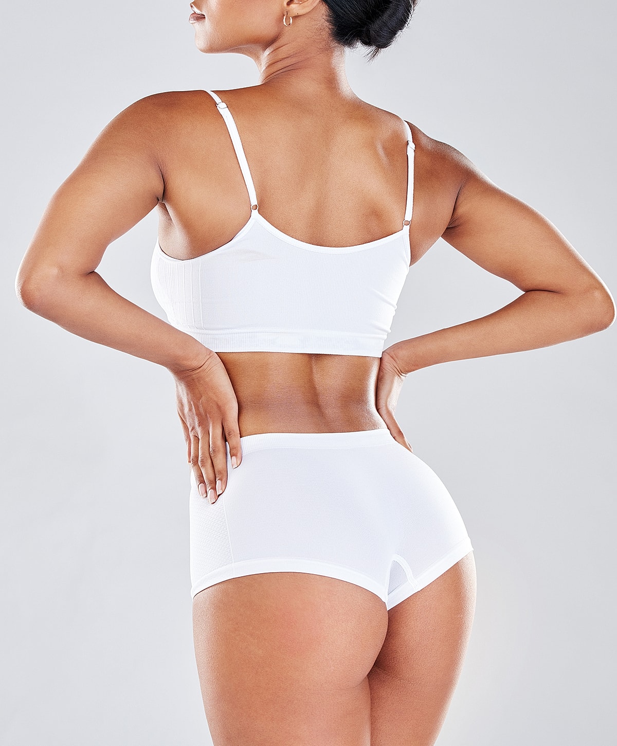Woman wearing white activewear, side view.