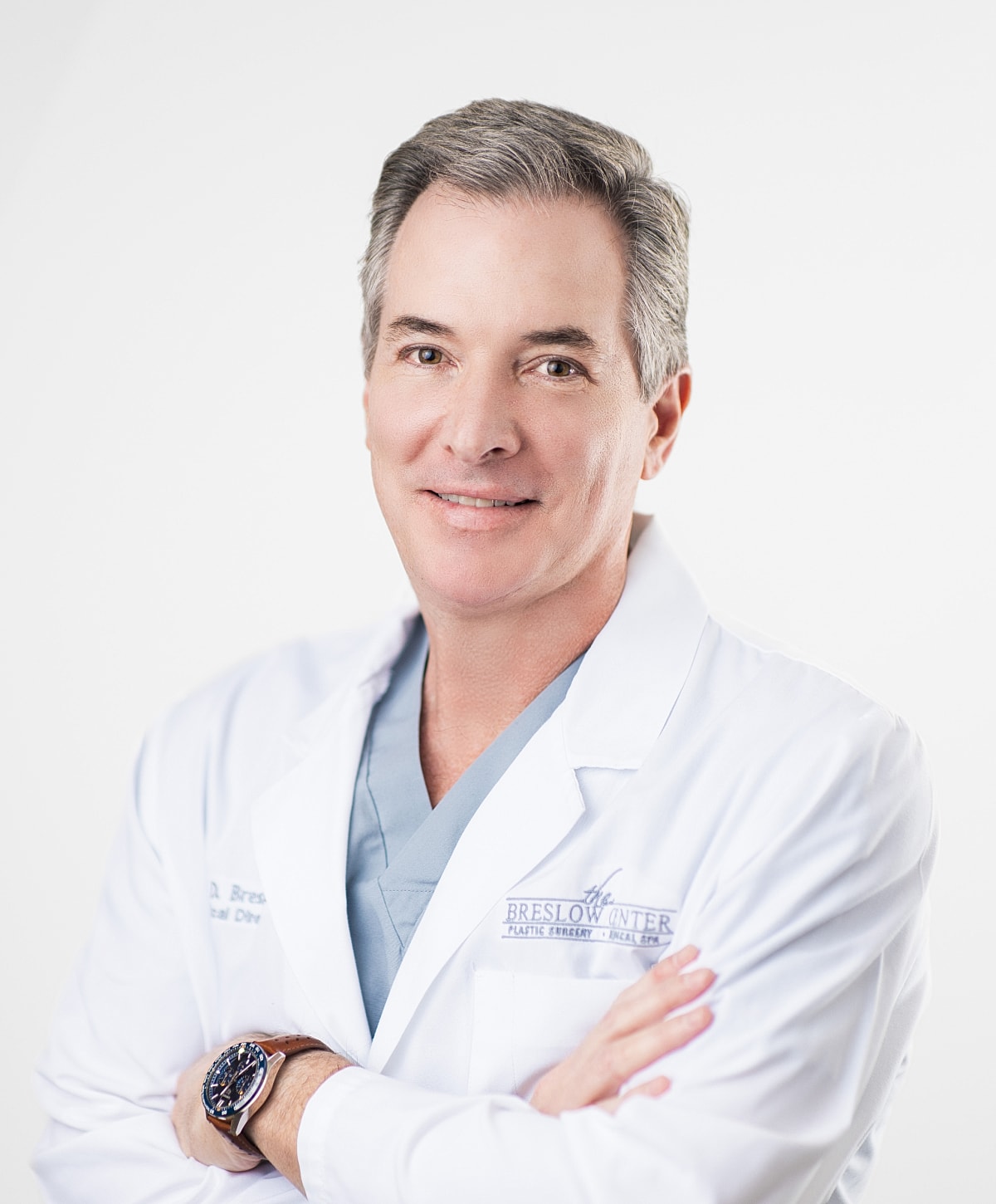 Doctor in white coat smiling confidently.