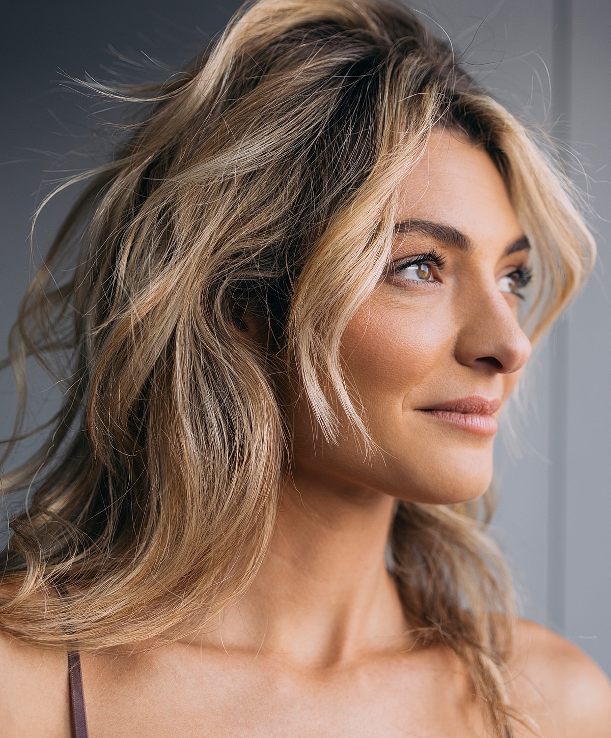 Young woman with stylish wavy hair looking sideways.