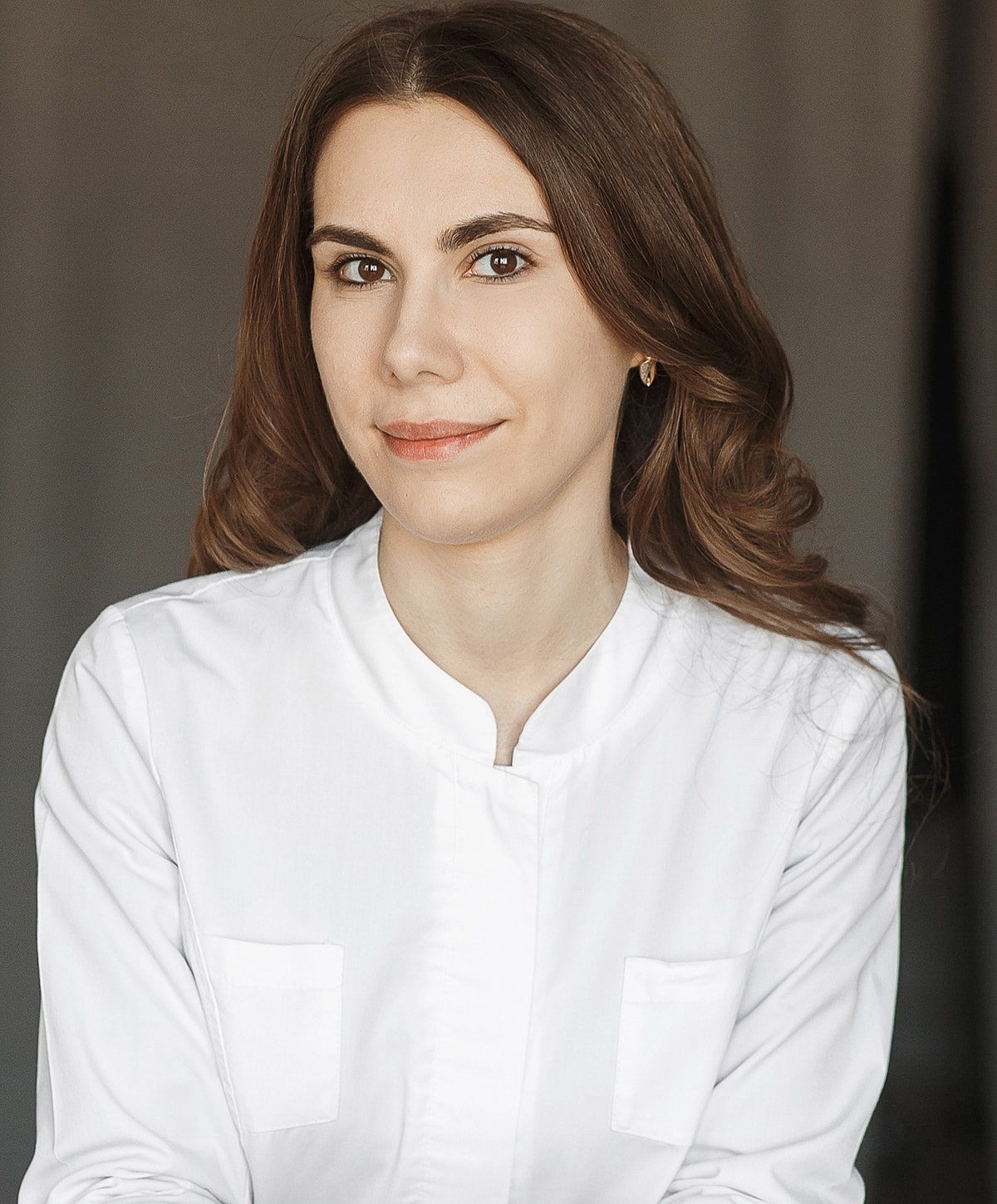 Woman in white shirt smiling at camera