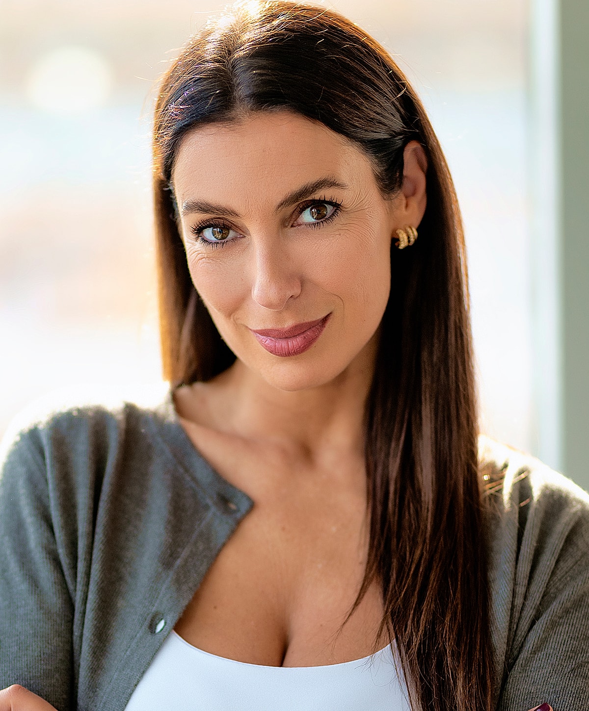 Woman with long hair, wearing a cardigan.