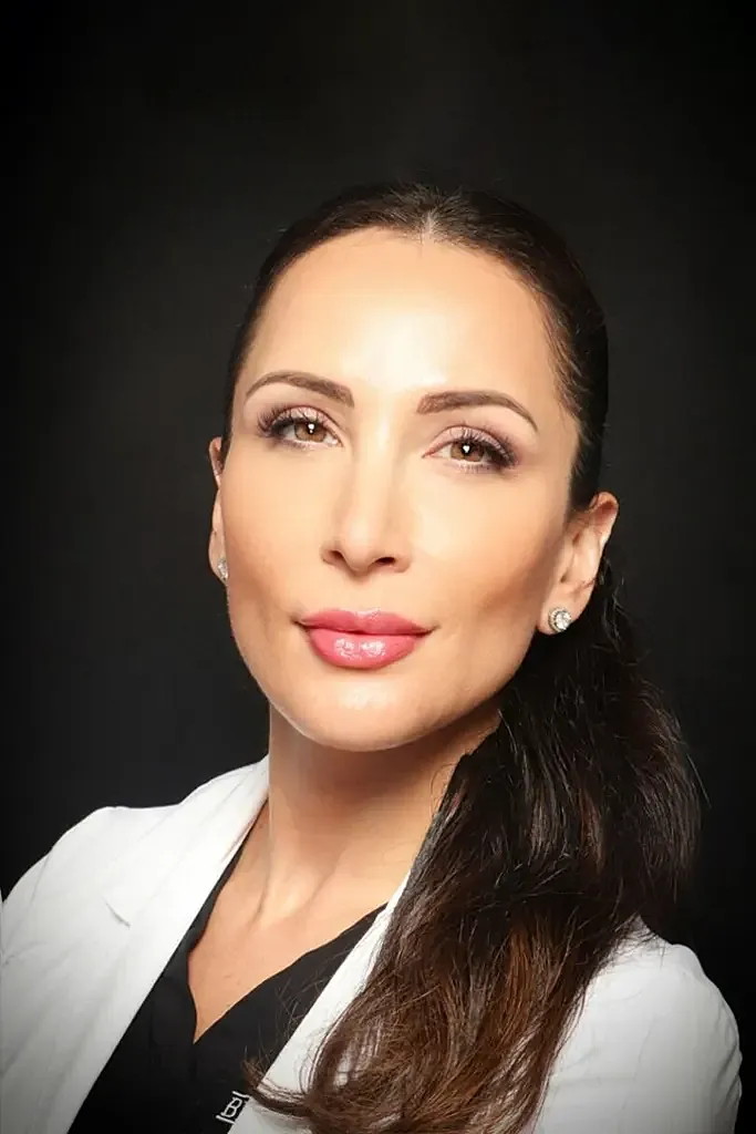Medical professional in white coat, confident expression.