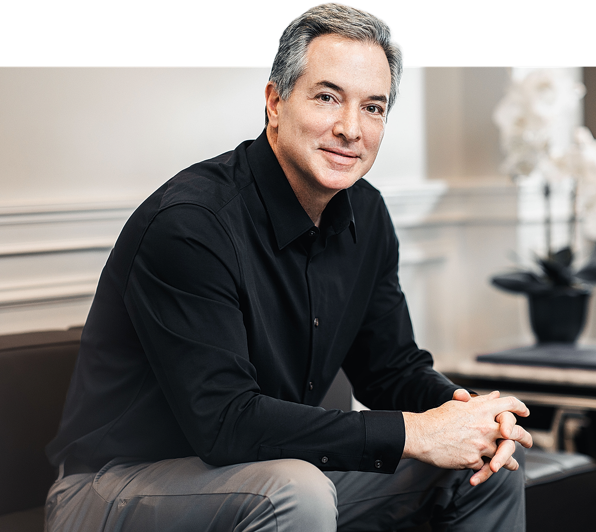Paramus plastic surgeon sitting in a modern setting.