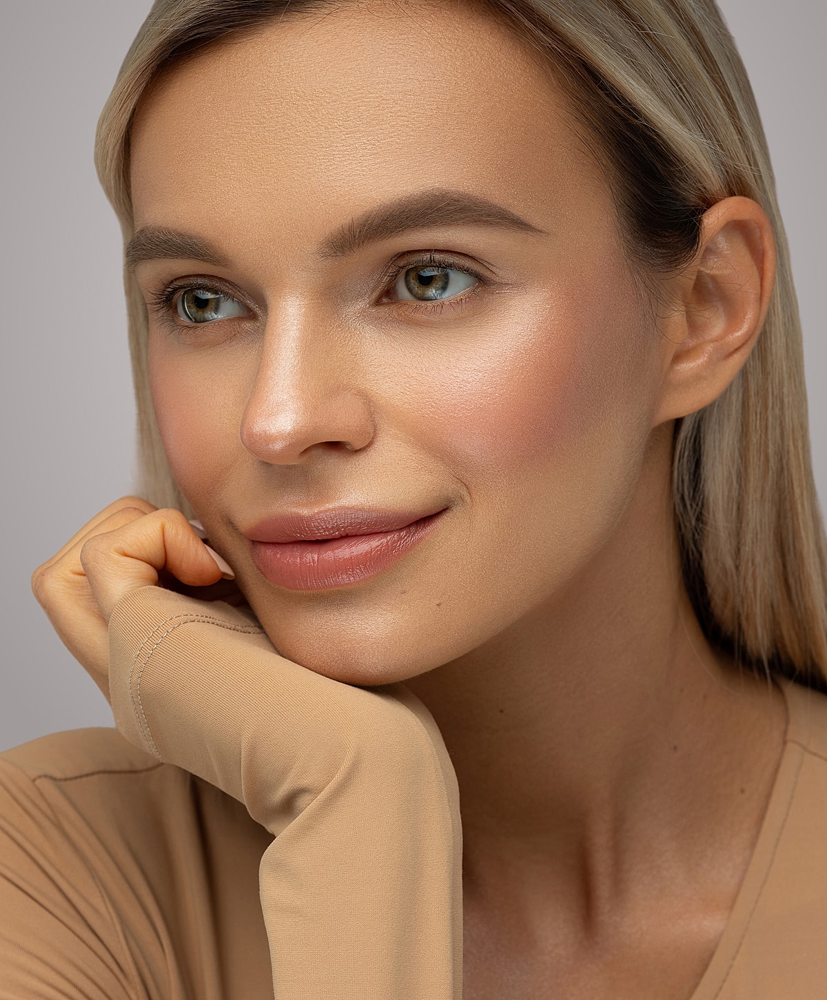 Woman with natural makeup and thoughtful expression.