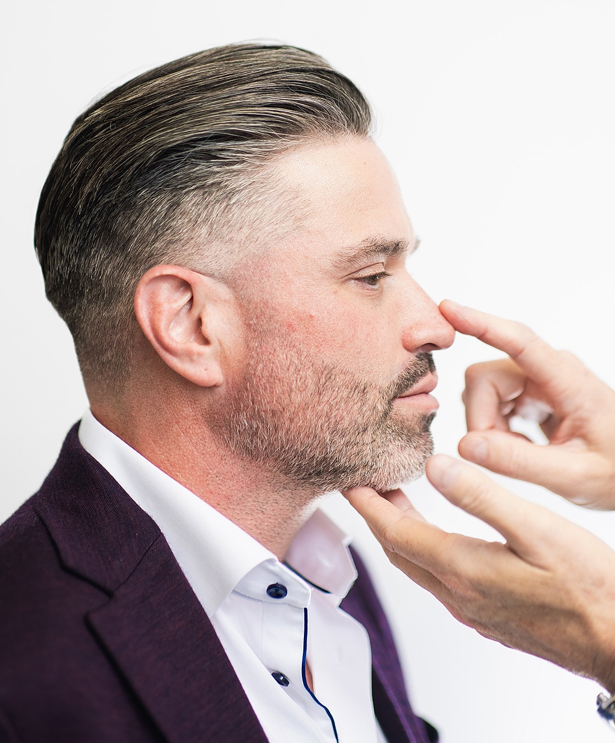 Profile view of man getting grooming touch-up.