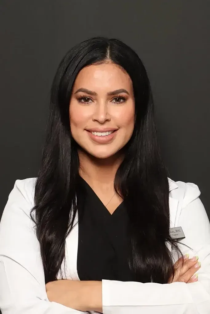 Smiling woman in professional attire, arms crossed.