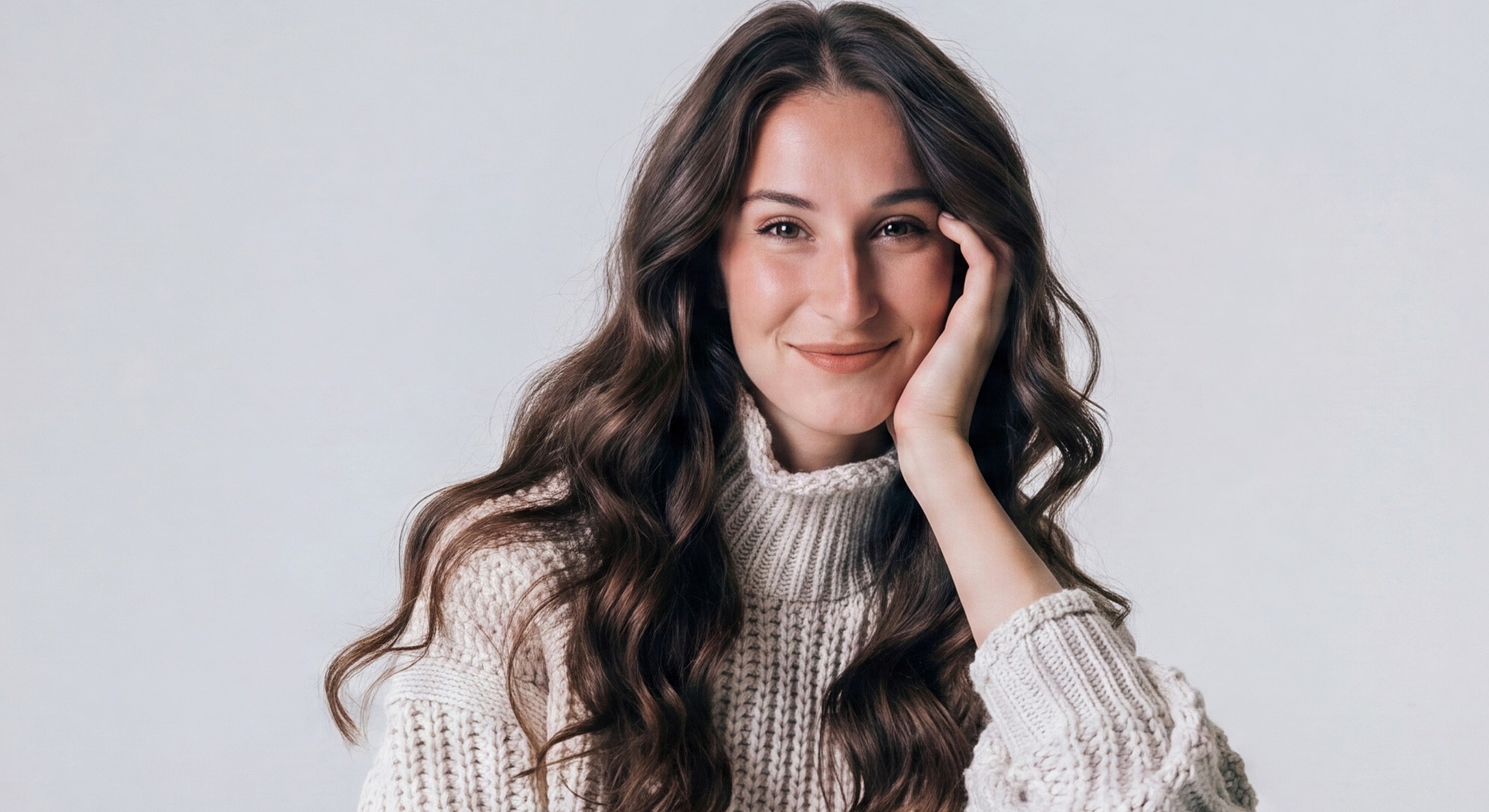 Smiling woman with long hair in cozy sweater.