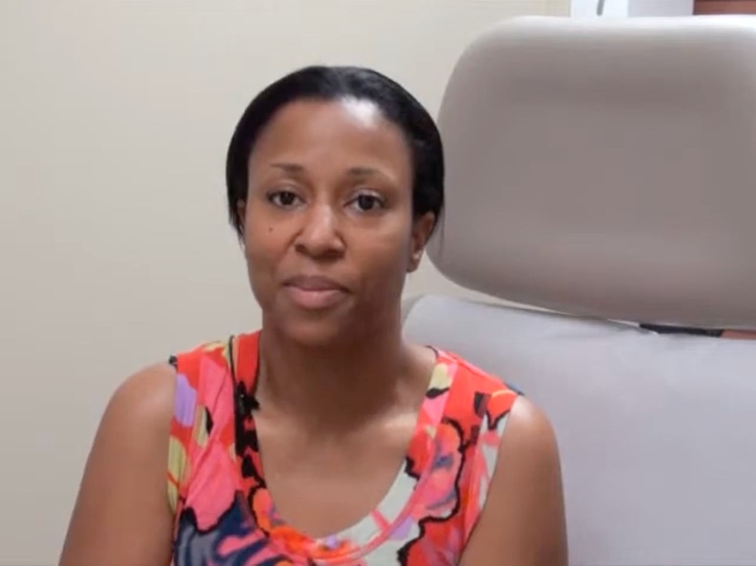 Woman in colorful shirt sitting in clinic chair