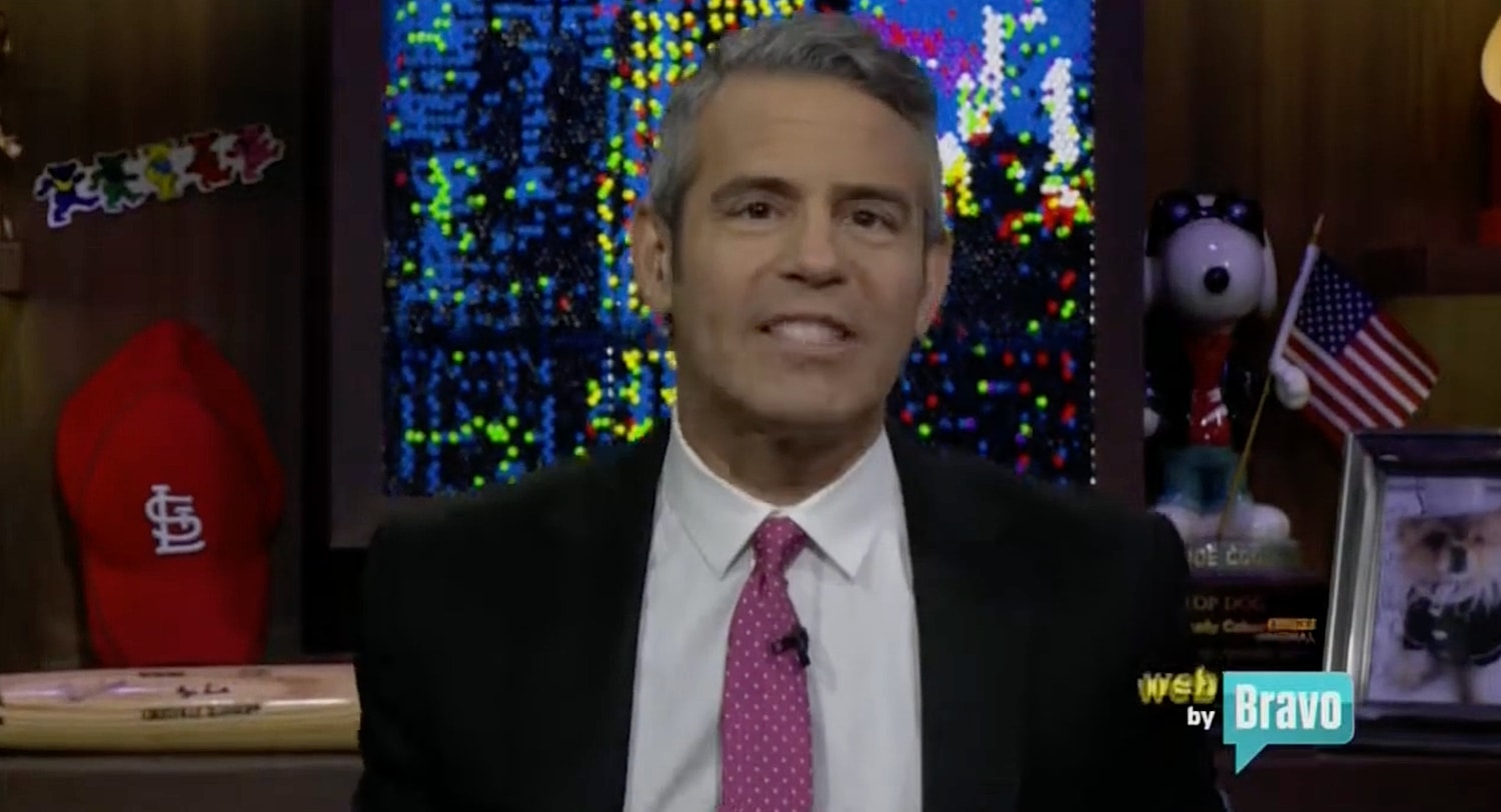 Man in suit speaking on a television show.