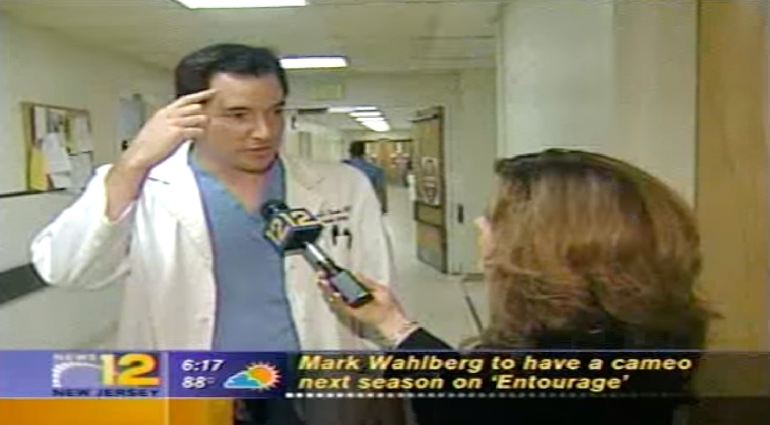 Doctor being interviewed in hospital hallway.